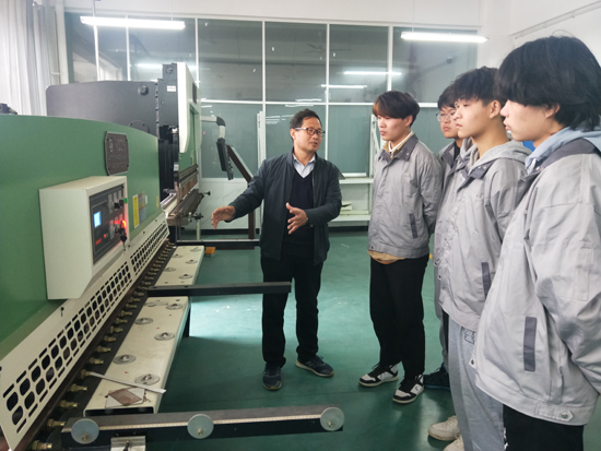 張仲欣教授給學(xué)生介紹剪板機的使用.jpg